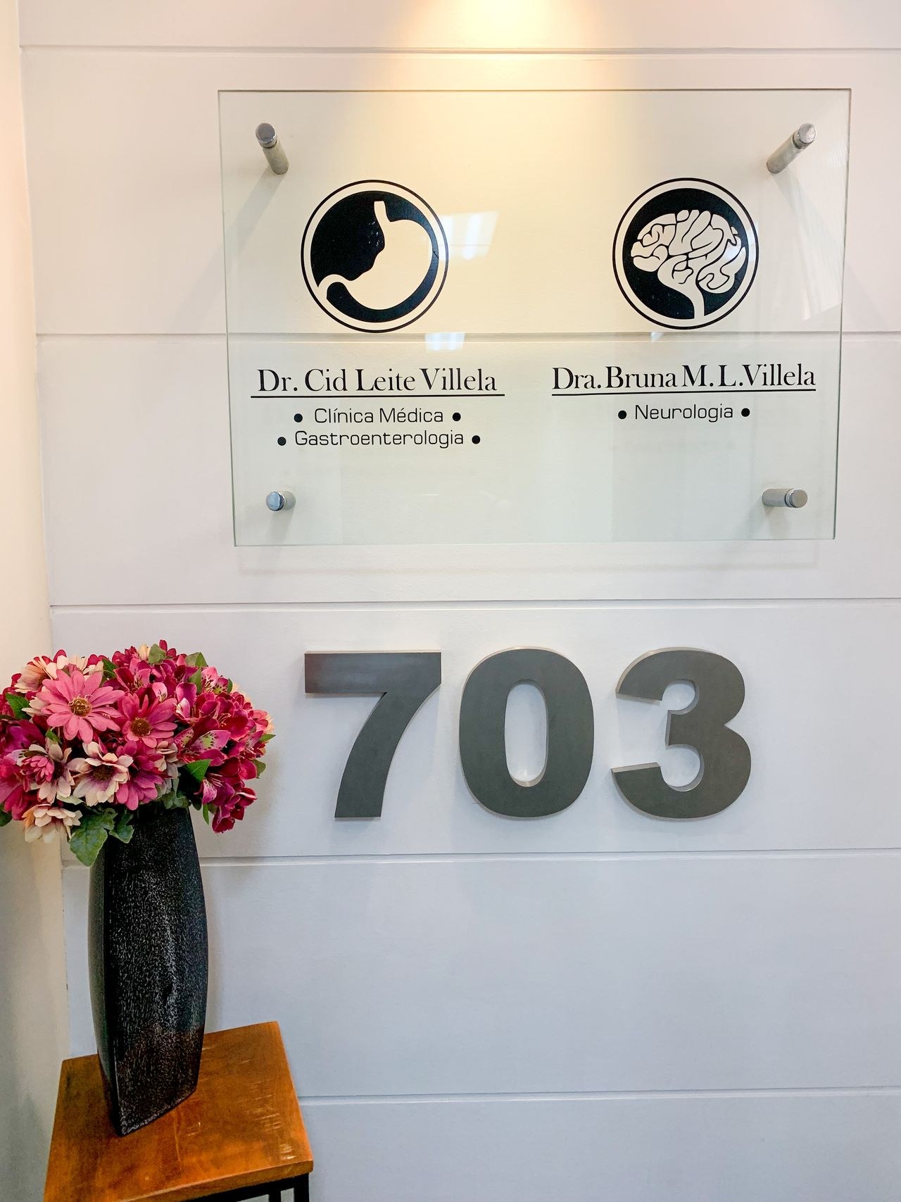Entrada do consultório com identificação da Dra. Bruna Villela, sala 703